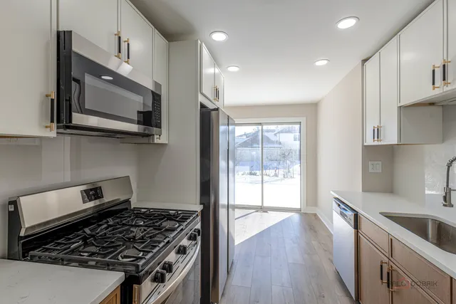 a kitchen with granite countertop a stove and a wooden floor