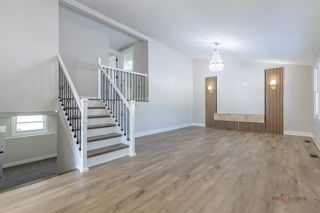 a view of a livingroom with wooden floor and stairs