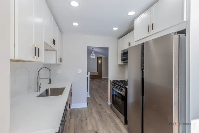 a kitchen with a refrigerator sink and cabinets