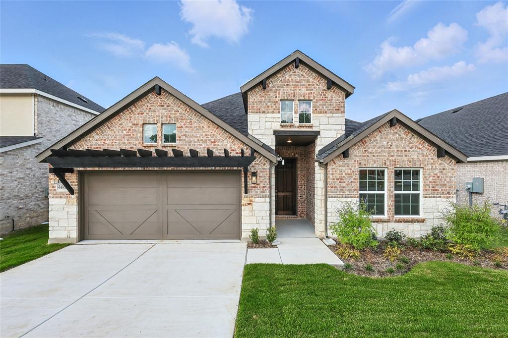 French provincial home featuring brick siding, driveway, stone siding, a shingled roof, and a front yard
