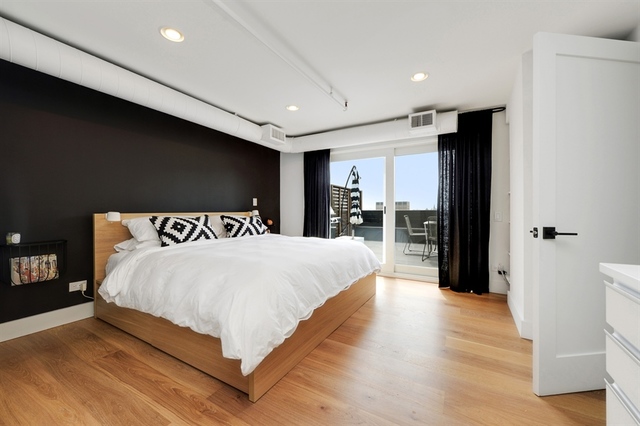 Undisclosed Address Chicago, IL 60607 - Photo 11 of 19 a large bedroom with a bed and wooden floor