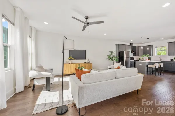 a living room with furniture a ceiling fan and a rug