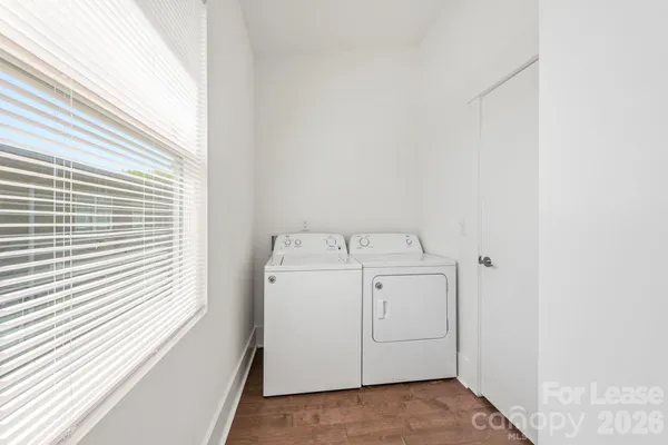 an empty room with wooden floor ceiling fan and windows