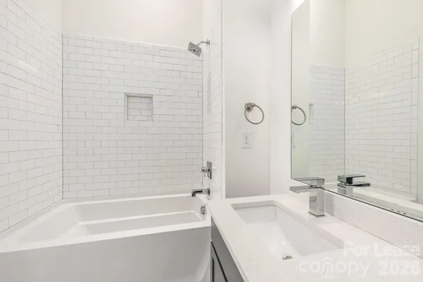 a bathroom with a tub sink and mirror