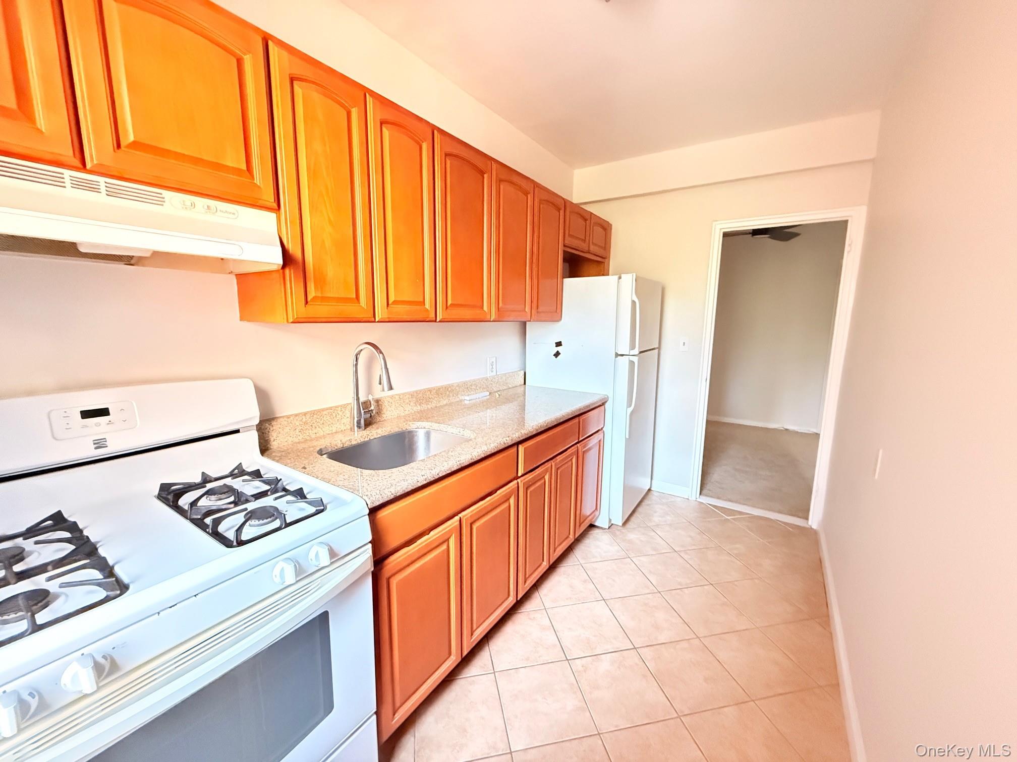a kitchen with stainless steel appliances a sink a stove a refrigerator and cabinets