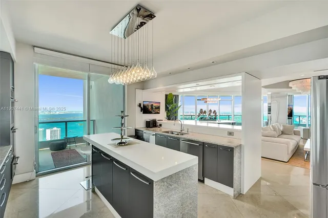 a view of living room kitchen with stainless steel appliances granite countertop furniture and a fireplace