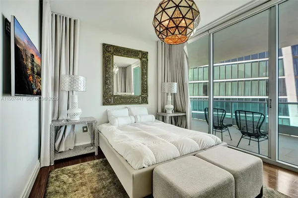 a bedroom with a bed and a lamp on dresser