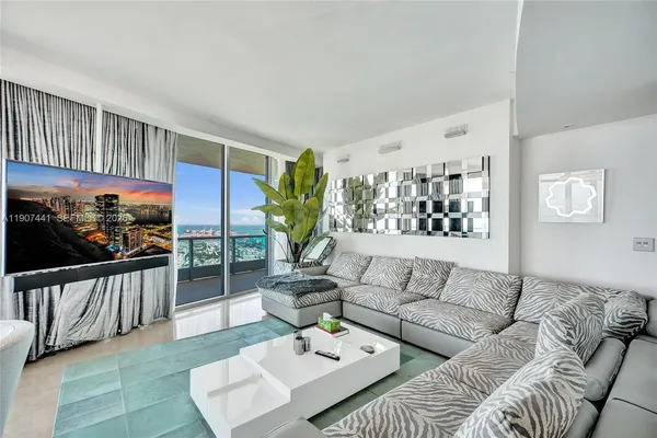 a living room with furniture a flat screen tv and a window