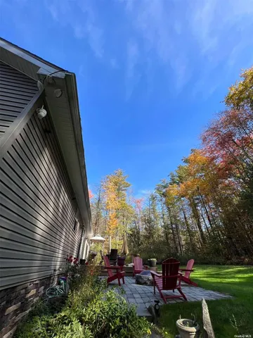 a view of backyard with outdoor seating and trees