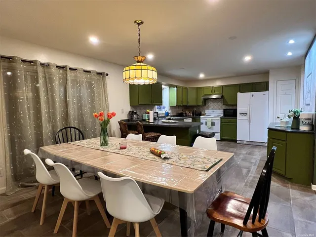 a view of a dining room and a kitchen with a table chairs