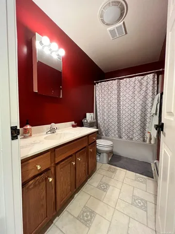 a bathroom with a double vanity sink toilet and shower