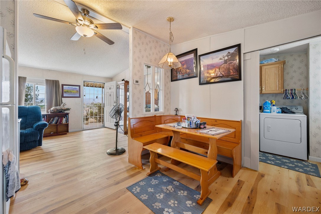 2465 Egar Road Golden Valley, AZ 86413 - Photo 25 of 98 The property features an open-concept living area with hardwood floors, a ceiling fan, and access to an outdoor area through a glass-paned door