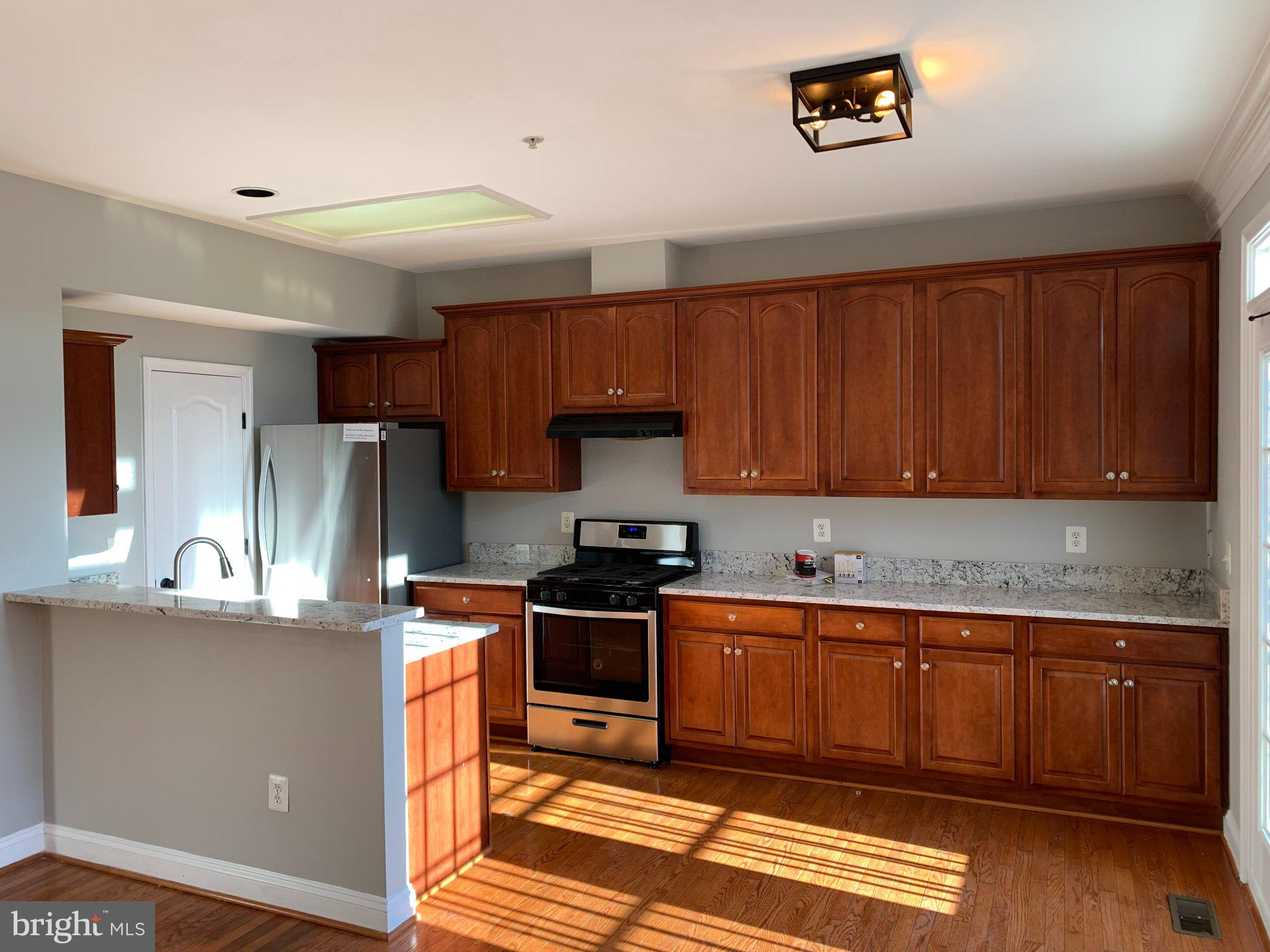 12956 Clarksburg Square Road Clarksburg, MD 20871 - Photo 2 of 16 Sunlit kitchen with rich wood cabinetry.