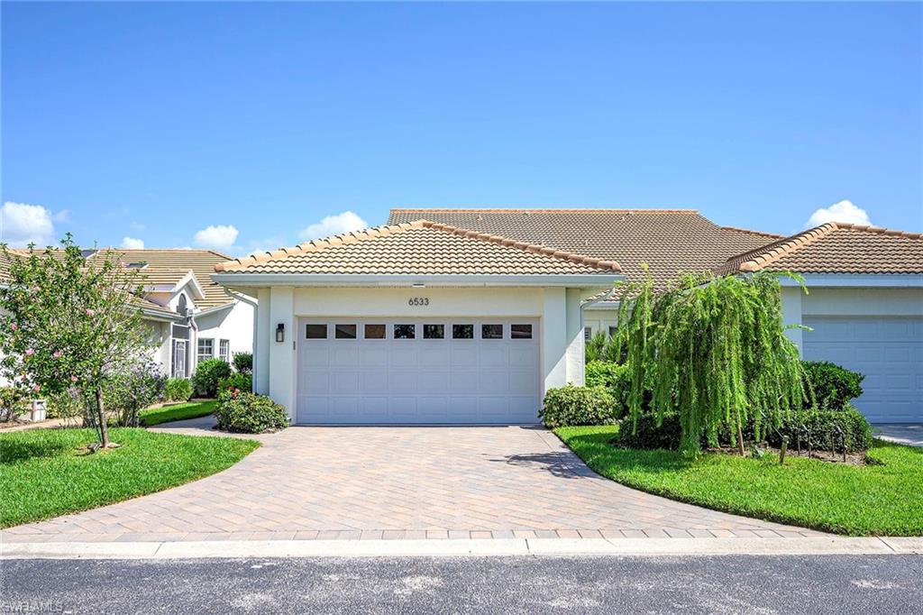 6533 Ilex Circle Naples, FL 34109 - Photo 1 of 34 a front view of a house with a garden