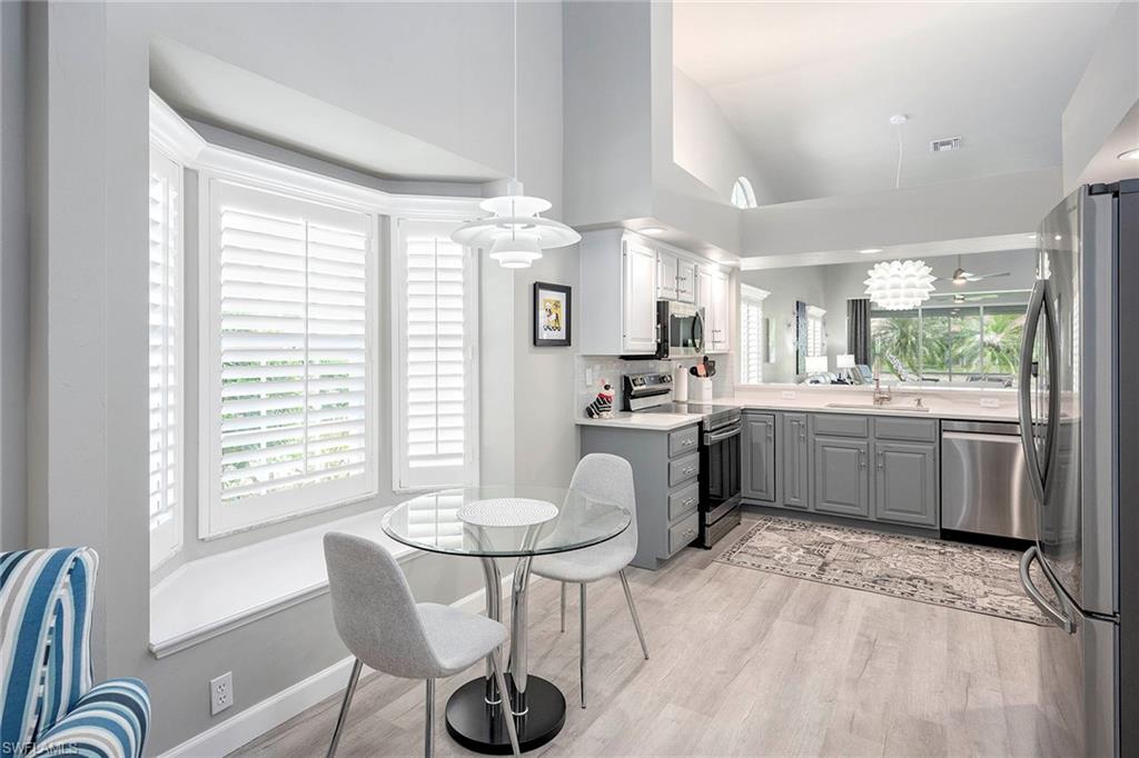 6533 Ilex Circle Naples, FL 34109 - Photo 20 of 34 a kitchen with a table chairs stove a sink dishwasher and cabinets