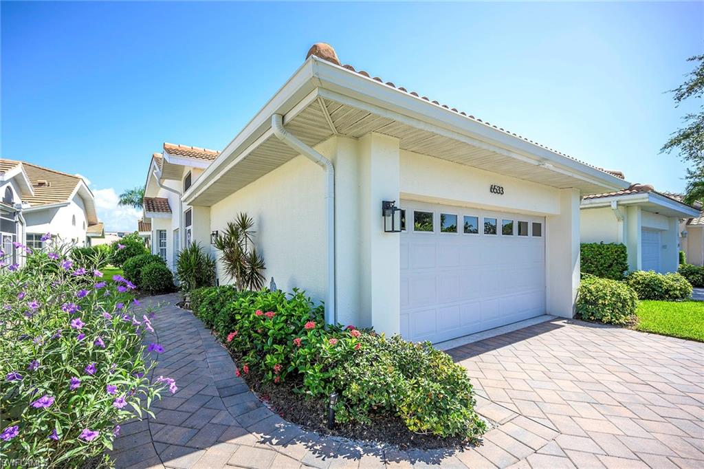 6533 Ilex Circle Naples, FL 34109 - Photo 2 of 34 a view of a house with a yard and flower plants