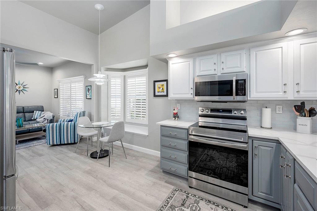6533 Ilex Circle Naples, FL 34109 - Photo 21 of 34 a kitchen with a stove a sink and a microwave