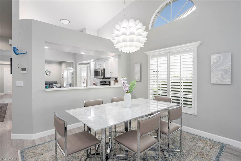 6533 Ilex Circle Naples, FL 34109 - Photo 23 of 34 a view of a dining room with furniture window and wooden floor
