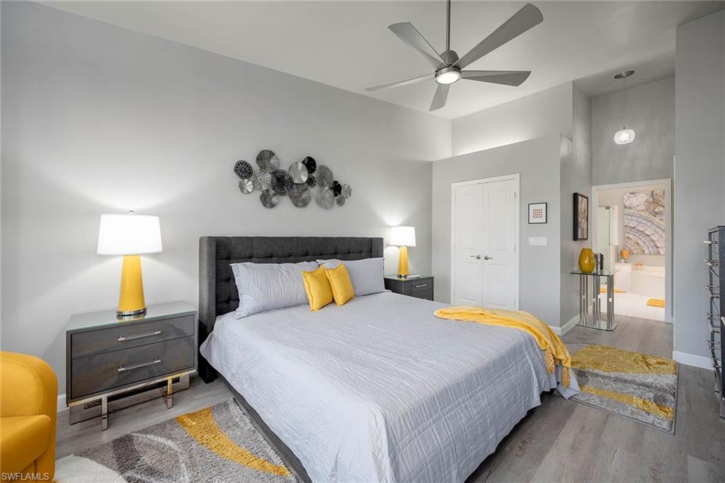 6533 Ilex Circle Naples, FL 34109 - Photo 29 of 34 a bedroom with a bed and wooden floor