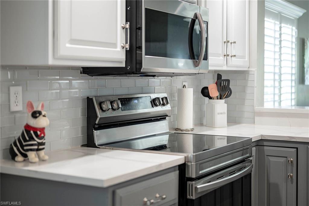 6533 Ilex Circle Naples, FL 34109 - Photo 7 of 34 a kitchen with a stove microwave and a sink