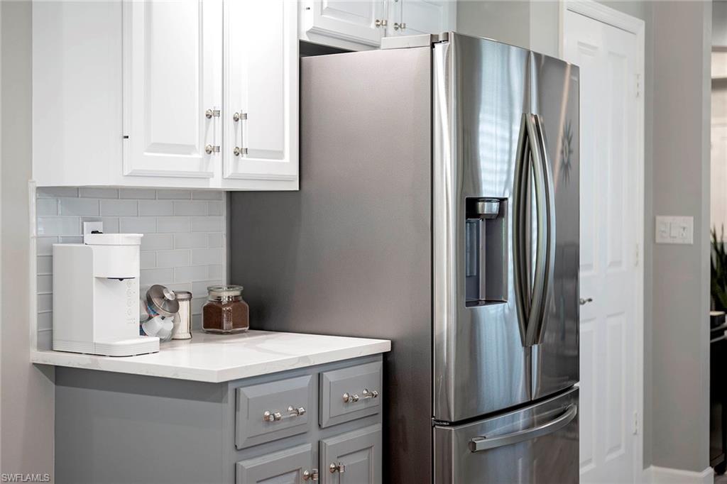 6533 Ilex Circle Naples, FL 34109 - Photo 9 of 34 a kitchen with appliances a refrigerator and cabinets
