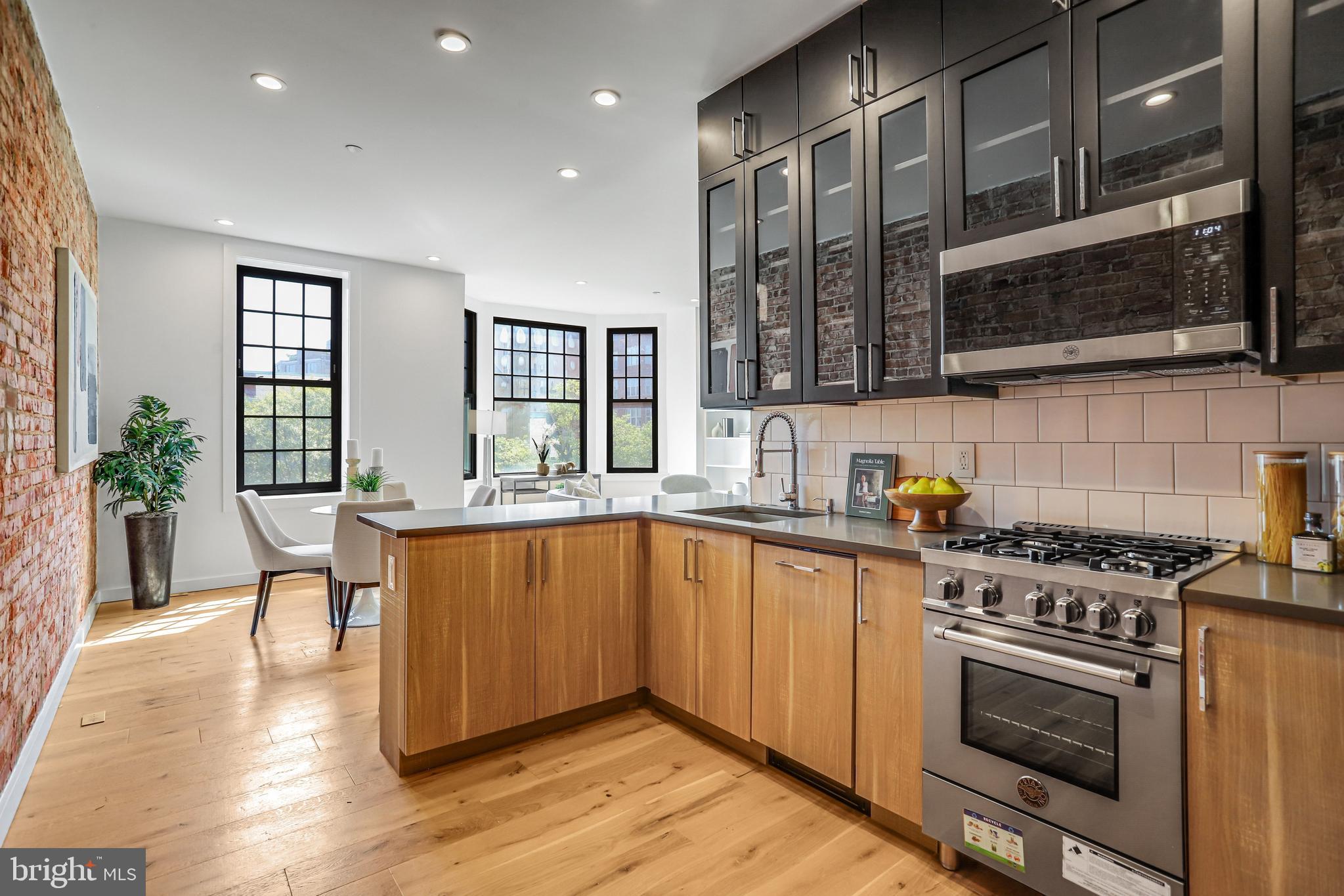 1412 15th Street Northwest, Unit 8 Washington, DC 20005 - Photo 5 of 15 a kitchen with stainless steel appliances a stove a sink and a microwave