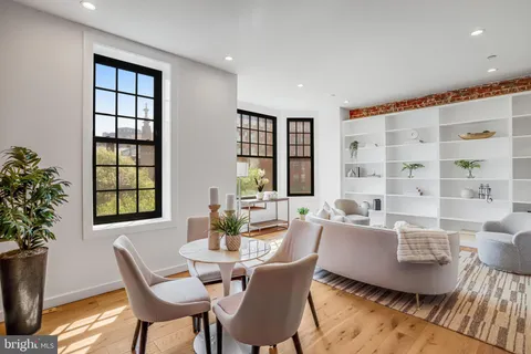a view of a dining room with furniture a kitchen and wooden floor