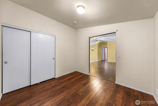 an empty room with wooden floor and entrance