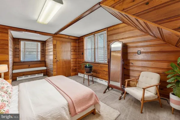 a bedroom with a bed chair and a large window