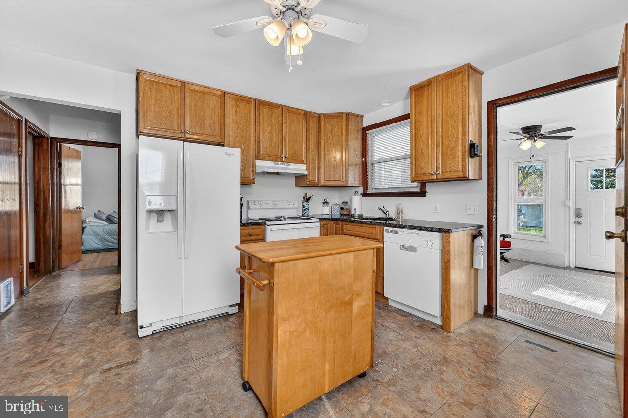 2062 Kinter Avenue Hamilton, NJ 08610 - Photo 8 of 19 a kitchen with stainless steel appliances granite countertop a refrigerator a sink a stove and white cabinets