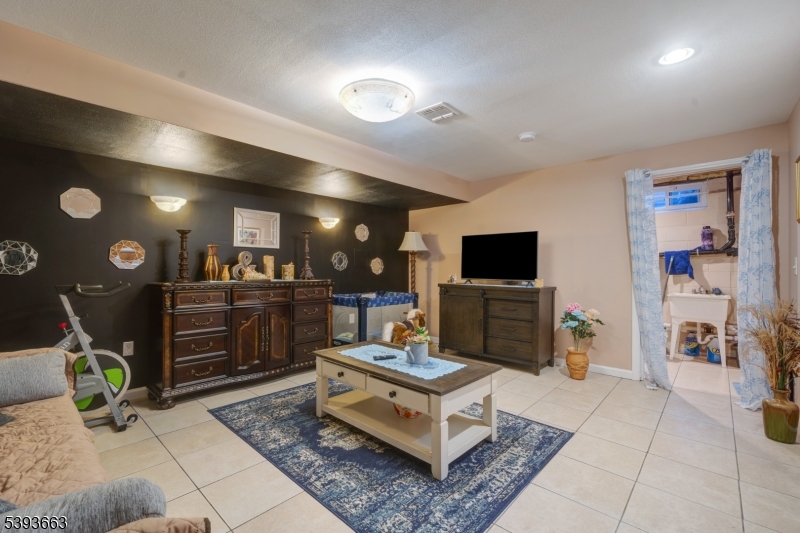 13 Valsumo Lane Newark, NJ 07105 - Photo 19 of 31 a living room with furniture and a flat screen tv