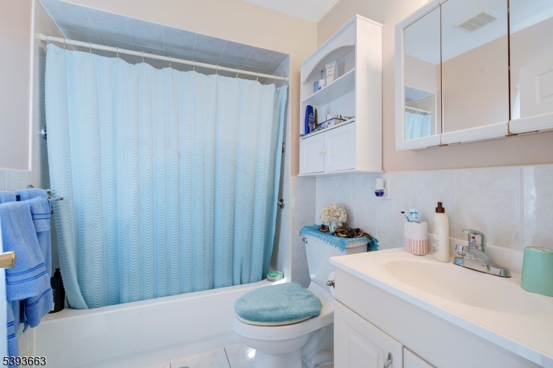 13 Valsumo Lane Newark, NJ 07105 - Photo 8 of 31 a bathroom with a sink a toilet and shower curtain