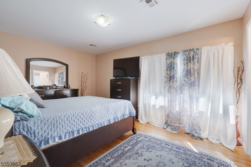 13 Valsumo Lane Newark, NJ 07105 - Photo 10 of 31 a bedroom with a bed and a mirror