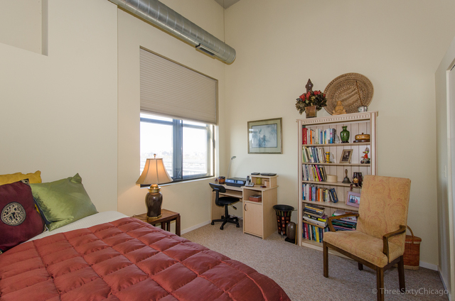 1524 South Sangamon Street, Unit 717S Chicago, IL 60608 - Photo 12 of 14 a bedroom with a bed a book shelf and a window