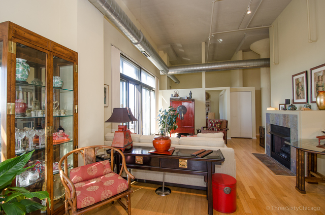 1524 South Sangamon Street, Unit 717S Chicago, IL 60608 - Photo 8 of 14 a living room with furniture a fireplace and a chandelier