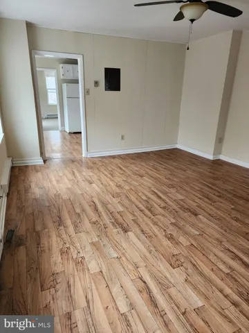 a view of empty room with wooden floor