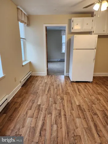 a view of a refrigerator in kitchen and wooden floor