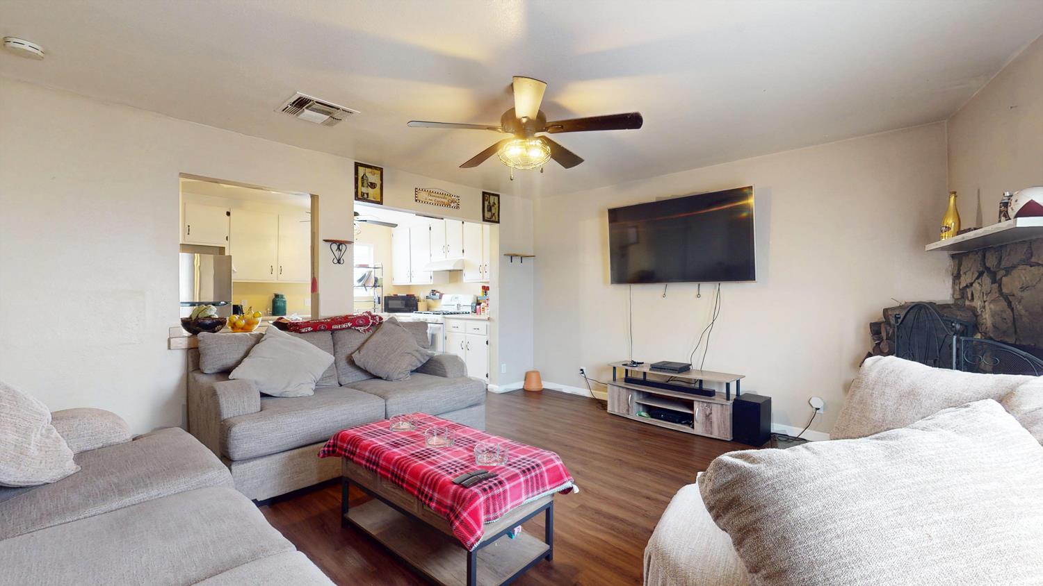 1526 8th Street Firebaugh, CA 93622 - Photo 29 of 57 a living room with furniture a flat screen tv and a window