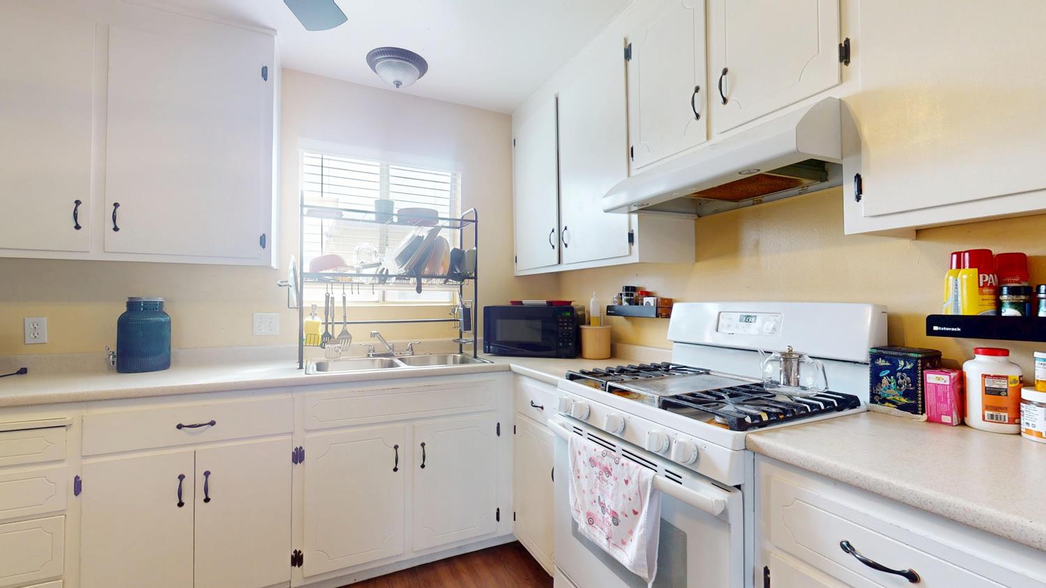 1526 8th Street Firebaugh, CA 93622 - Photo 33 of 57 a kitchen with cabinets a stove and a sink