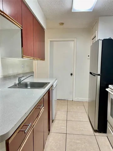 a kitchen with stainless steel appliances granite countertop a sink and a refrigerator