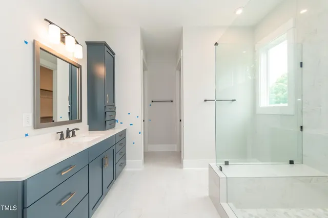 a bathroom with a double vanity sink mirror and shower