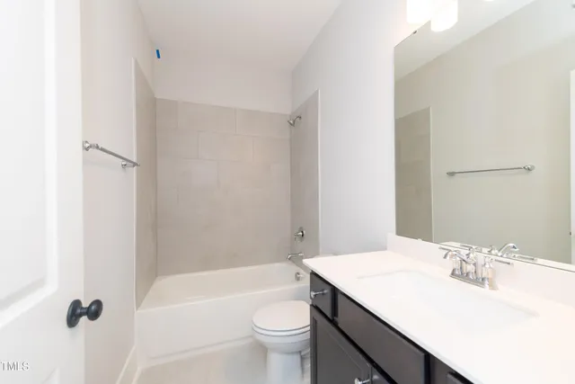 a bathroom with a sink a toilet a mirror and shower