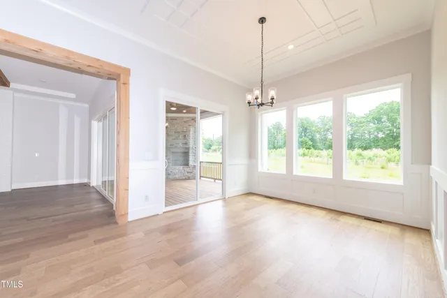 a view of an empty room with glass door and windows