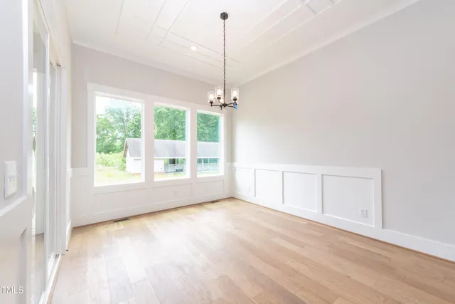 a view of a room with window wooden floor and front door