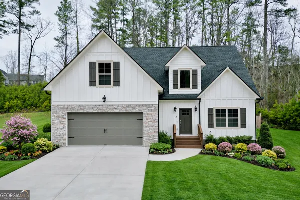 a front view of a house with a garden and plants