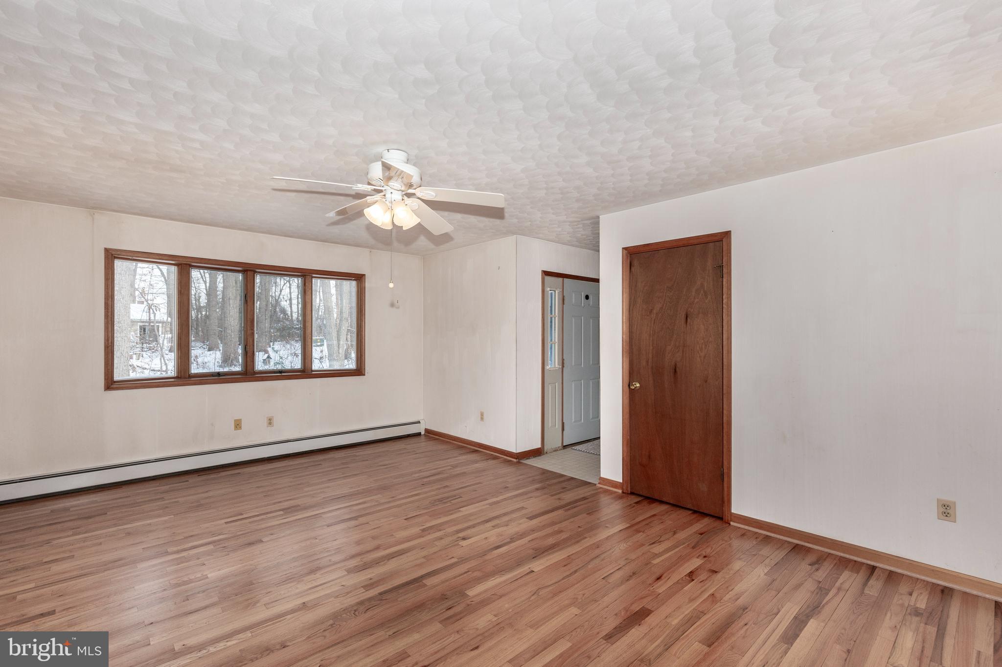 4437 Dave Rill Road Hampstead, MD 21074 - Photo 17 of 68 a view of an empty room with a window and wooden floor