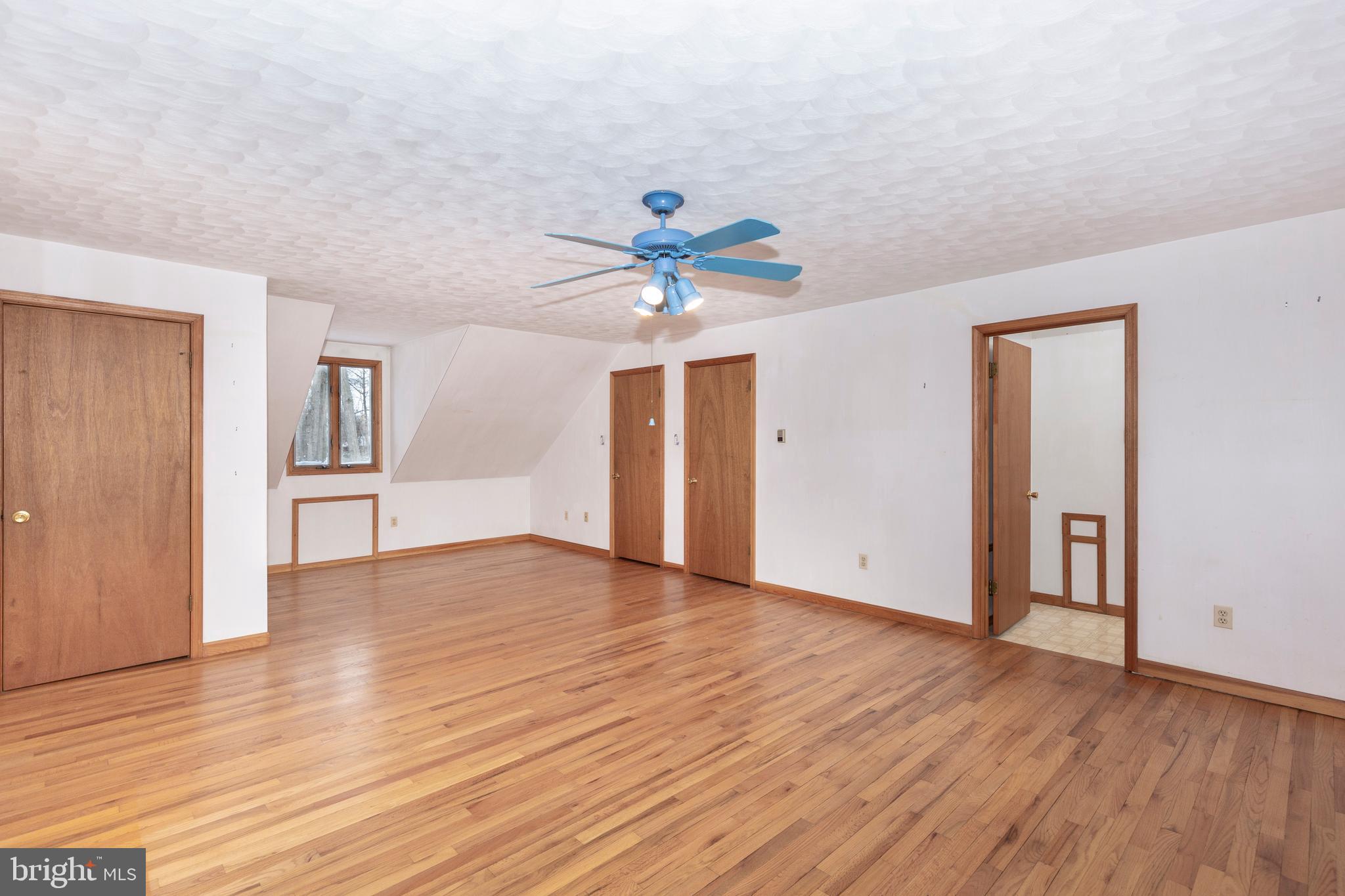 4437 Dave Rill Road Hampstead, MD 21074 - Photo 32 of 68 a view of an empty room with wooden floor and a ceiling fan