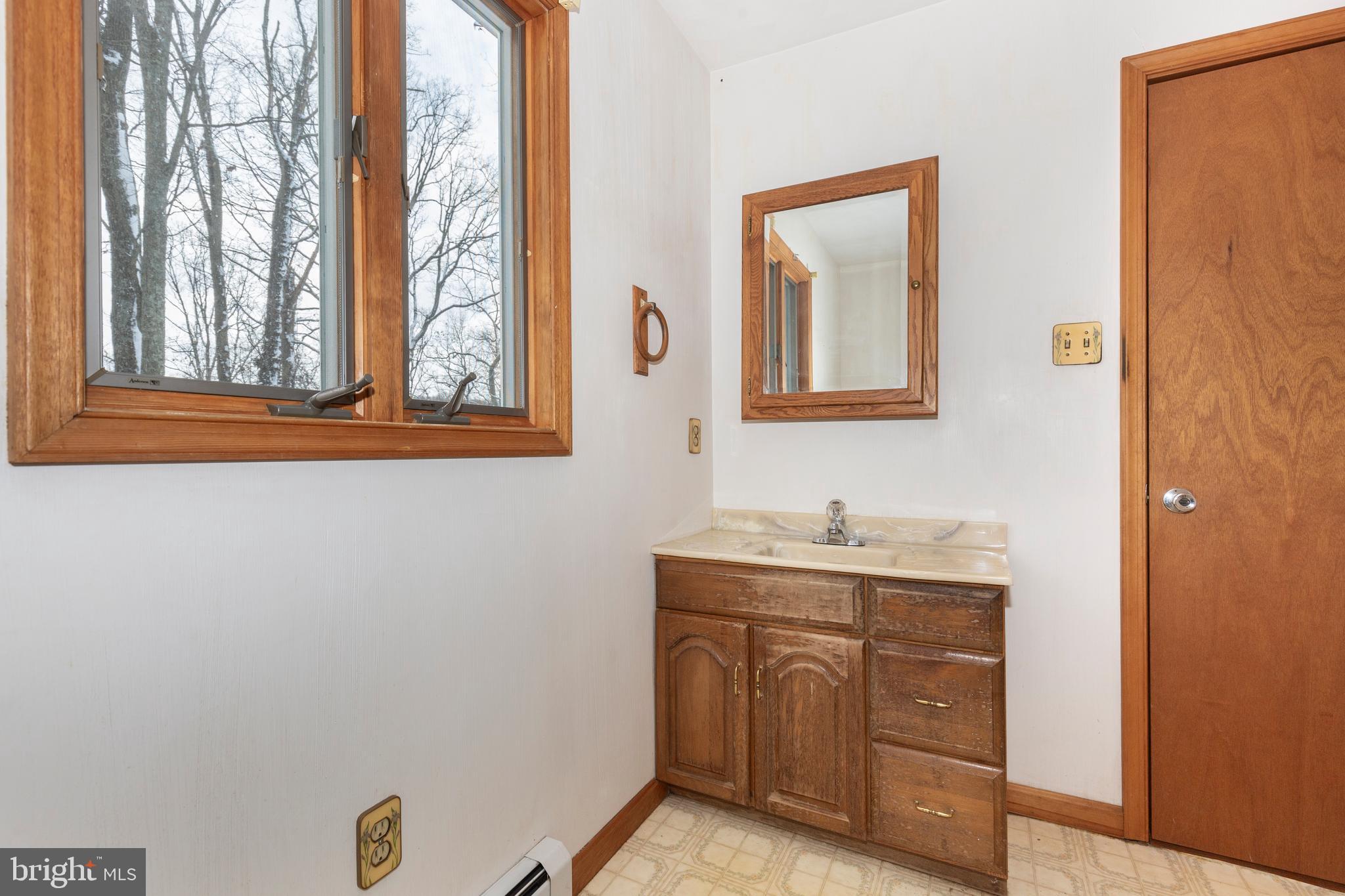 4437 Dave Rill Road Hampstead, MD 21074 - Photo 33 of 68 a bathroom with a granite countertop sink a mirror and a window