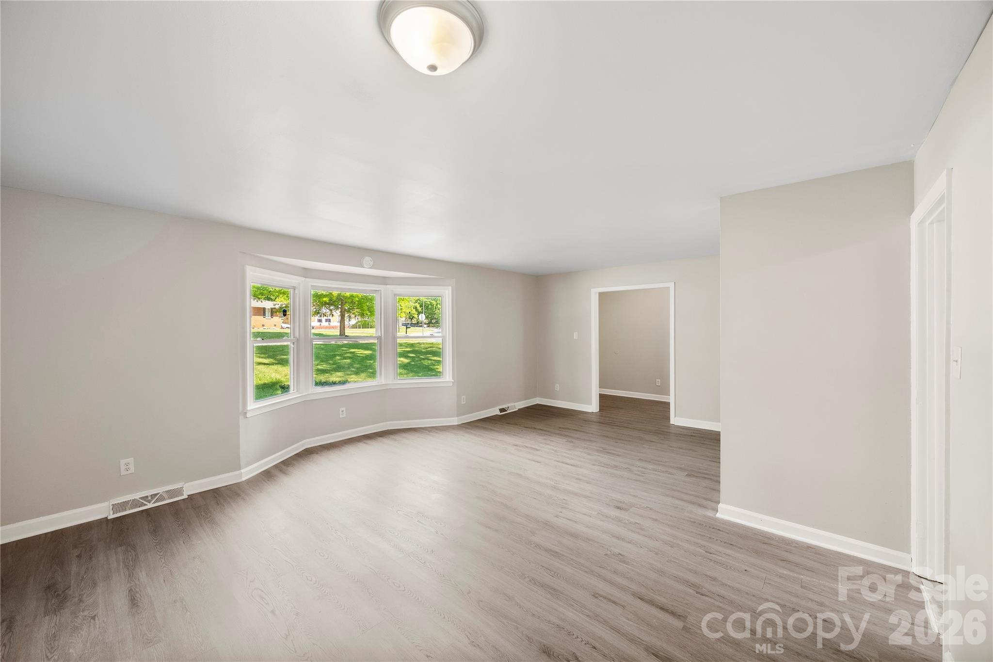 7001 Crossridge Road Charlotte, NC 28214 - Photo 13 of 30 an empty room with wooden floor and windows