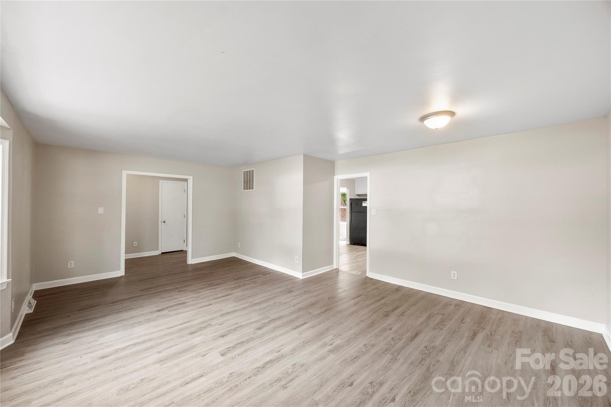7001 Crossridge Road Charlotte, NC 28214 - Photo 19 of 30 an empty room with wooden floor & windows and bathroom